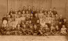 Řídící učitel Eduard Vohnout (uprostřed vlevo) P. Alois Slovák s žactvem školy v roce 1900. Zdroj: AMB, fond B 39 Obec Bohunice, fotografická dokumentace ke kronikám Bohunic z let 1900-1978.